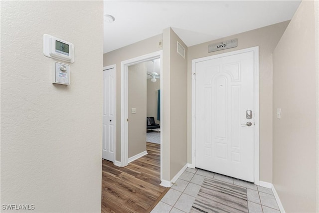 foyer entrance with visible vents, baseboards, and light tile patterned floors