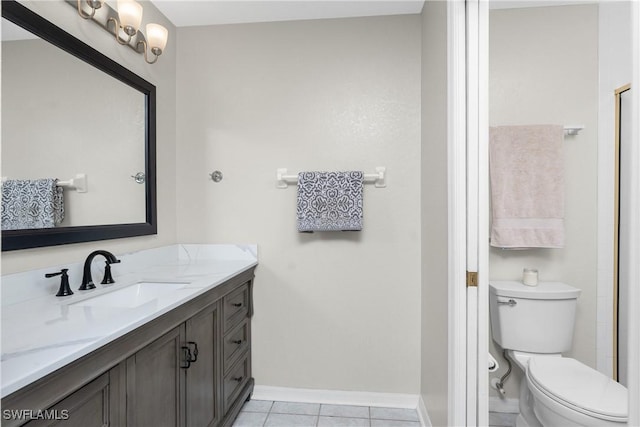 bathroom with toilet, tile patterned flooring, baseboards, and vanity