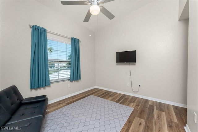 living area featuring ceiling fan, baseboards, and wood finished floors