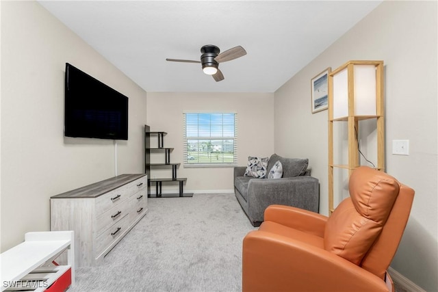 sitting room with ceiling fan, baseboards, and light colored carpet