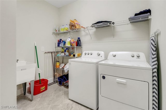 laundry room featuring washer and clothes dryer and light tile patterned floors