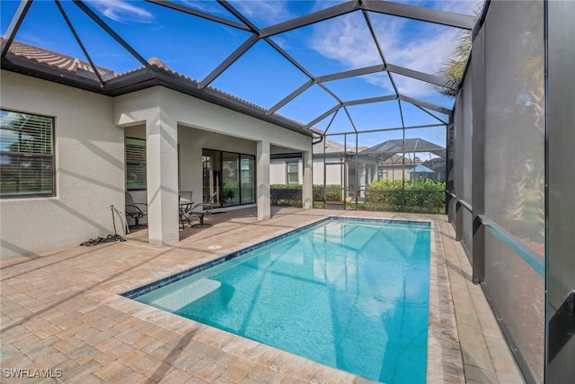 view of swimming pool featuring a lanai and a patio area