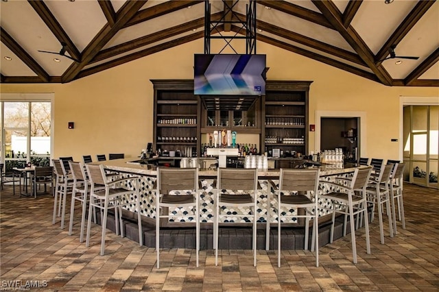 dining space featuring beamed ceiling, a wealth of natural light, and high vaulted ceiling