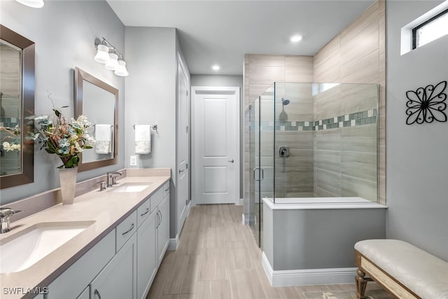 full bathroom featuring a stall shower, a sink, baseboards, and double vanity