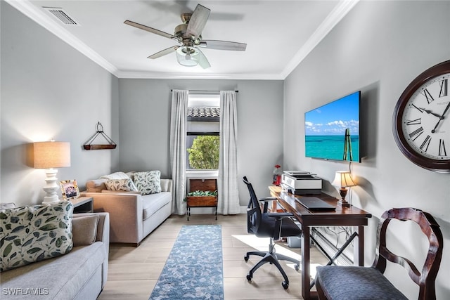 home office with light wood finished floors, ornamental molding, visible vents, and a ceiling fan