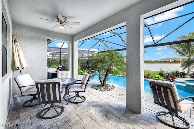 sunroom / solarium featuring a water view and a ceiling fan