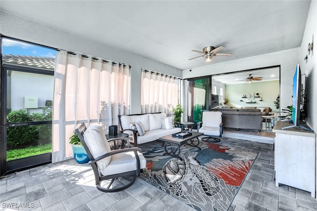 sunroom / solarium featuring ceiling fan