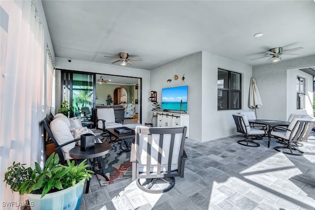 sunroom featuring a ceiling fan