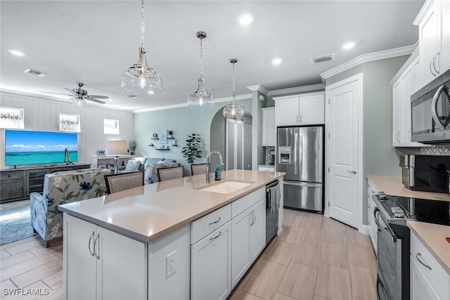 kitchen featuring open floor plan, stainless steel appliances, an island with sink, and white cabinetry