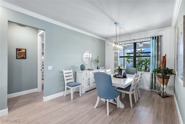 dining space with baseboards, ornamental molding, light wood-style flooring, and a chandelier