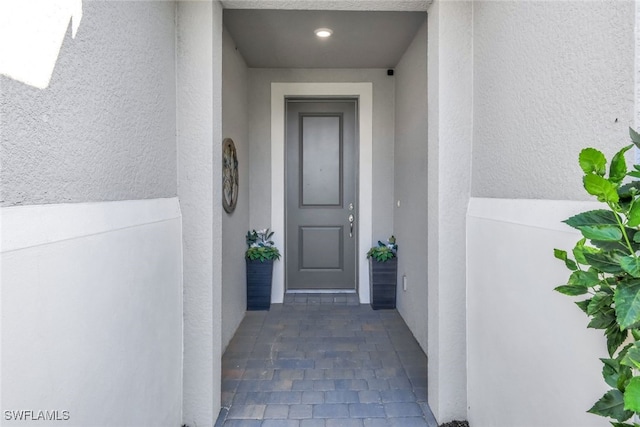 view of exterior entry with stucco siding