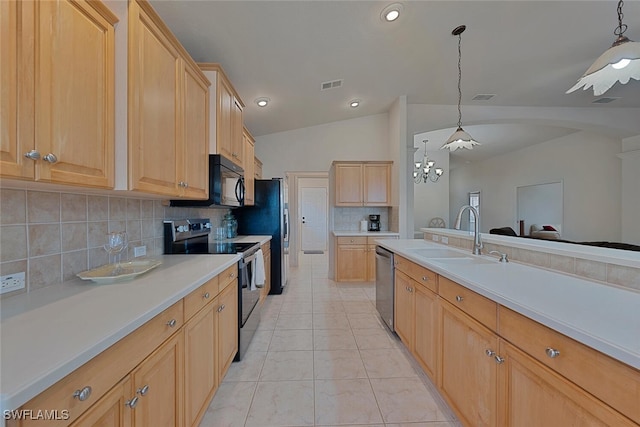 kitchen with lofted ceiling, sink, appliances with stainless steel finishes, light brown cabinetry, and decorative light fixtures