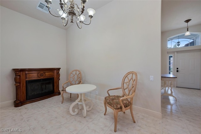 sitting room with vaulted ceiling and a notable chandelier