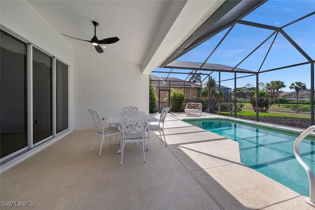 view of pool with ceiling fan, glass enclosure, and a patio area