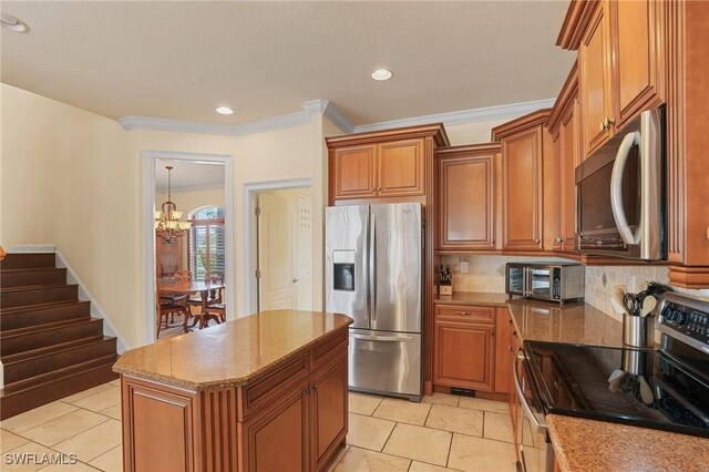 kitchen with appliances with stainless steel finishes, a toaster, brown cabinetry, and light stone countertops