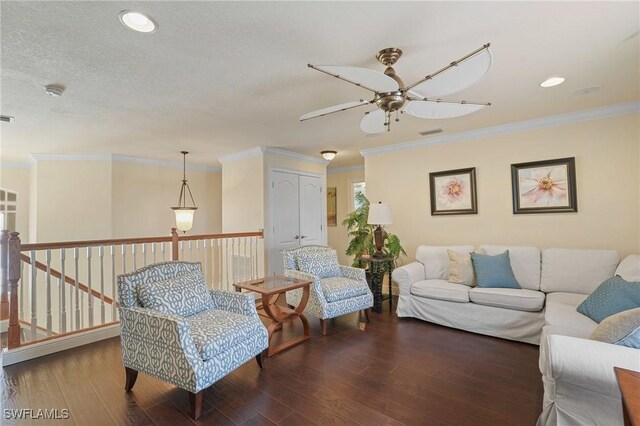 living room with crown molding, visible vents, and wood finished floors