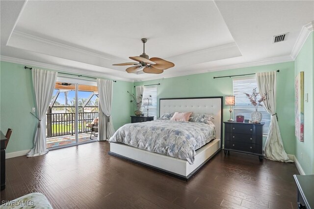 bedroom with access to exterior, ornamental molding, a raised ceiling, and dark wood-style flooring