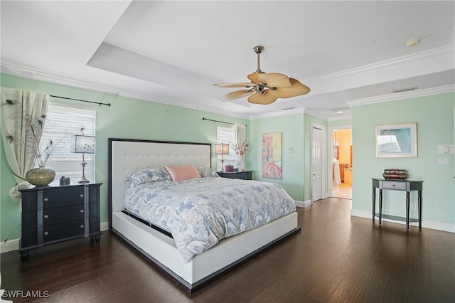 bedroom featuring multiple windows, a tray ceiling, and wood finished floors