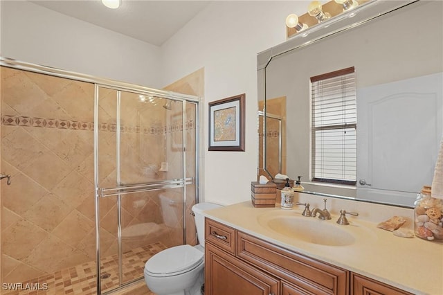 bathroom with a stall shower, vanity, and toilet