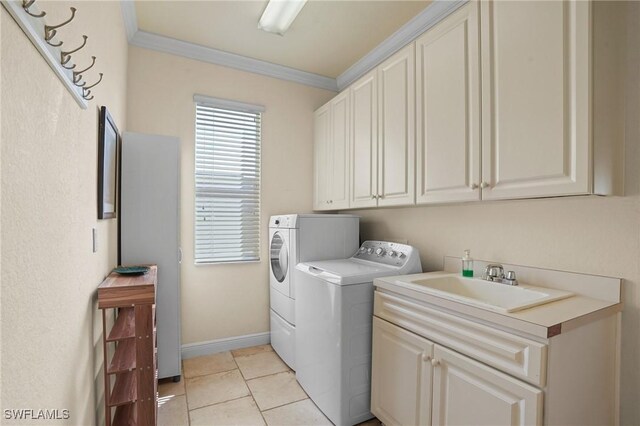 clothes washing area with crown molding, light tile patterned floors, cabinet space, a sink, and washer and dryer