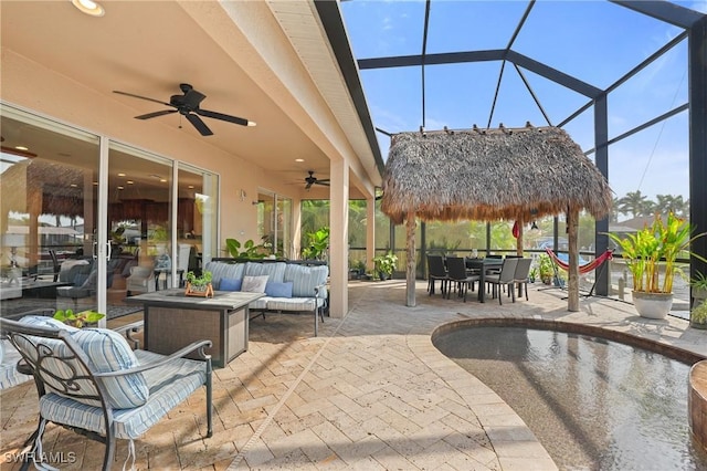 view of patio / terrace with outdoor lounge area, glass enclosure, outdoor dining area, and a ceiling fan