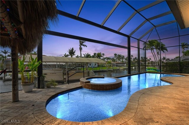 view of pool featuring a pool with connected hot tub, glass enclosure, and a patio