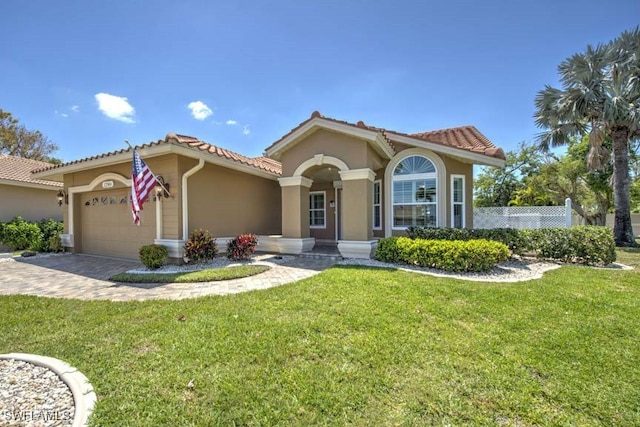 mediterranean / spanish home featuring a garage and a front lawn