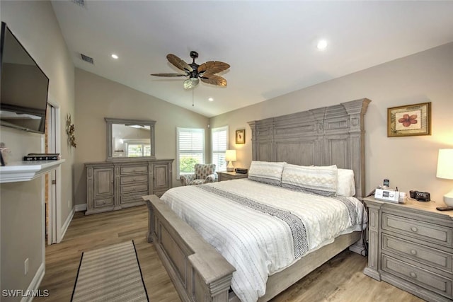 bedroom with ceiling fan, vaulted ceiling, and light hardwood / wood-style flooring