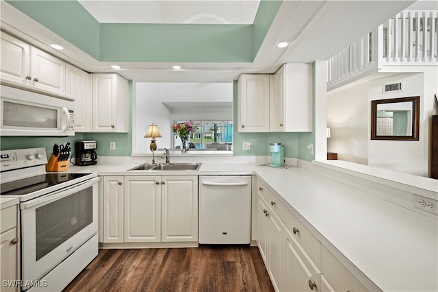 kitchen with dark hardwood / wood-style floors, sink, white cabinets, and white appliances