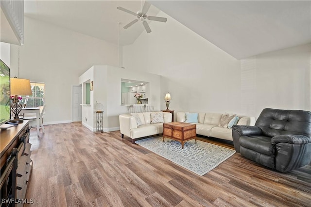 living room featuring ceiling fan, hardwood / wood-style floors, and high vaulted ceiling