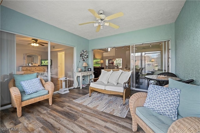 living room featuring hardwood / wood-style floors, a textured ceiling, and ceiling fan