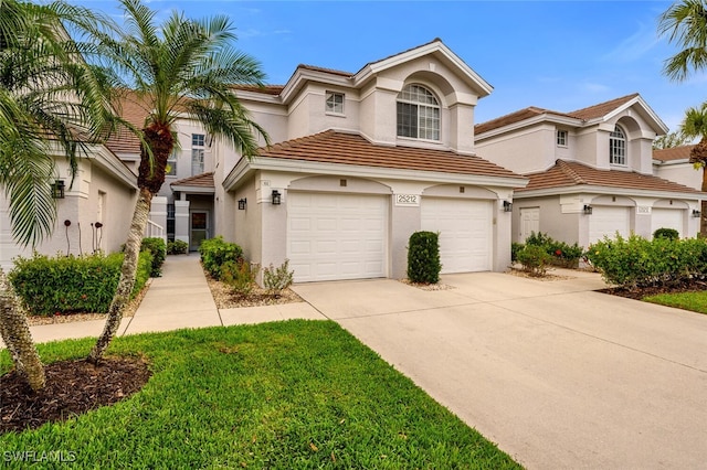 mediterranean / spanish home with driveway, an attached garage, a tiled roof, and stucco siding