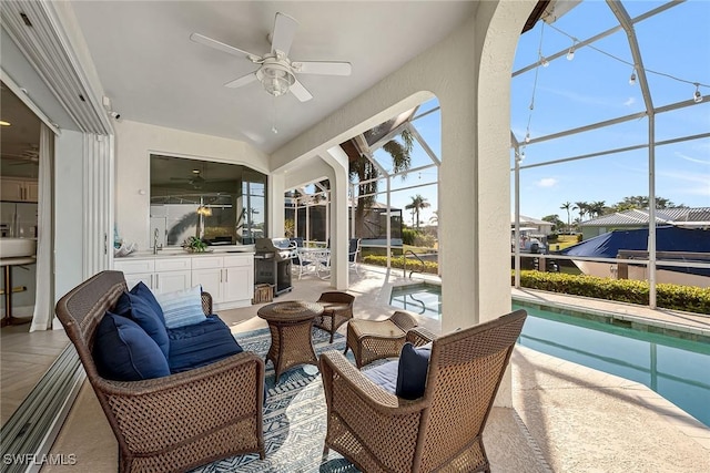 sunroom with ceiling fan, a pool, plenty of natural light, and sink