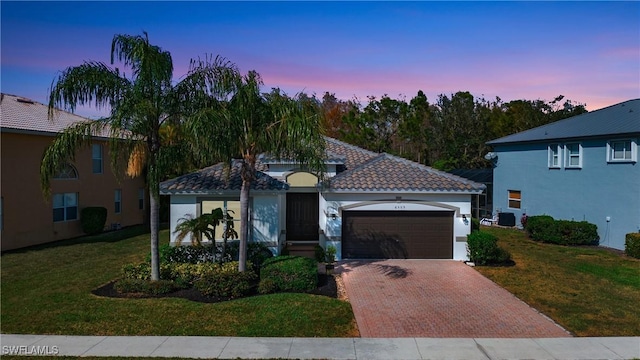 view of front of home featuring a garage and a lawn