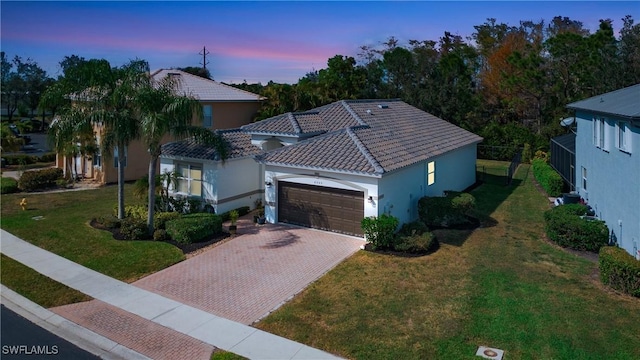 view of front of property featuring a garage and a lawn