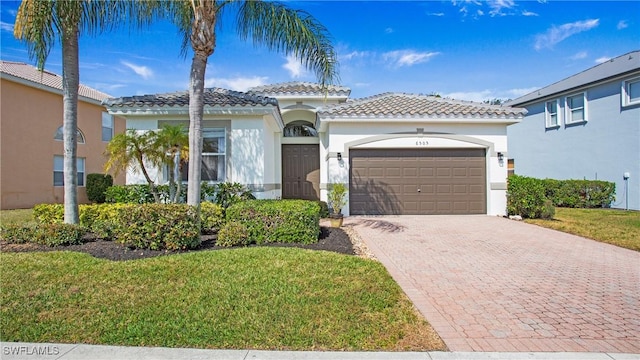 mediterranean / spanish house featuring a garage and a front yard