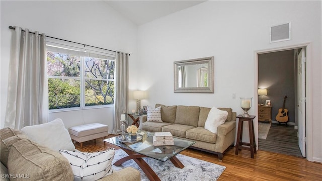 living room featuring vaulted ceiling and hardwood / wood-style floors