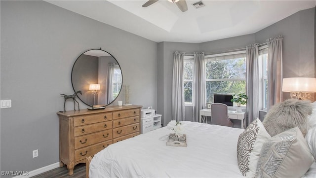 bedroom featuring ceiling fan, dark hardwood / wood-style floors, and a raised ceiling