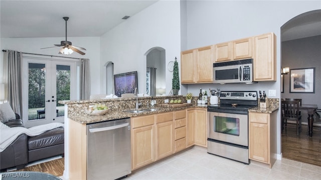 kitchen with sink, light brown cabinets, kitchen peninsula, and appliances with stainless steel finishes