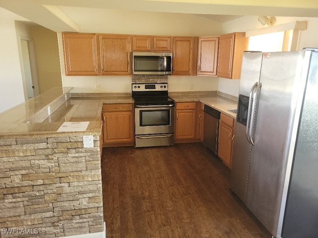 kitchen featuring dark wood-type flooring, stainless steel appliances, and kitchen peninsula