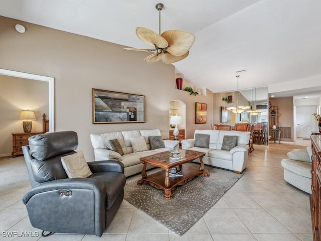 living room featuring lofted ceiling, light tile patterned floors, arched walkways, and a ceiling fan