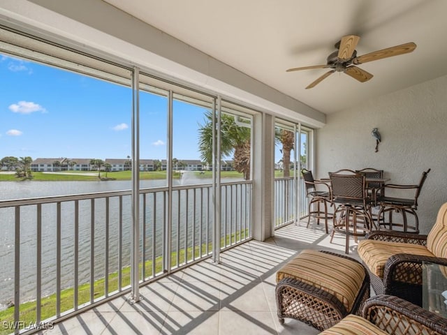 sunroom with a water view and a ceiling fan