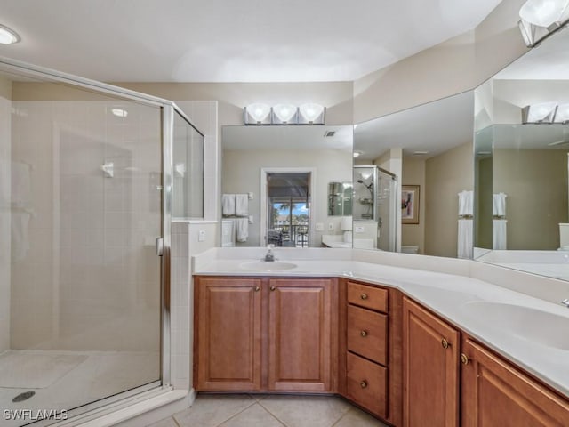 bathroom with double vanity, tile patterned flooring, a sink, and a shower stall