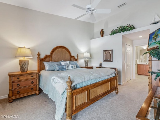 bedroom featuring ensuite bathroom, light colored carpet, a ceiling fan, baseboards, and visible vents