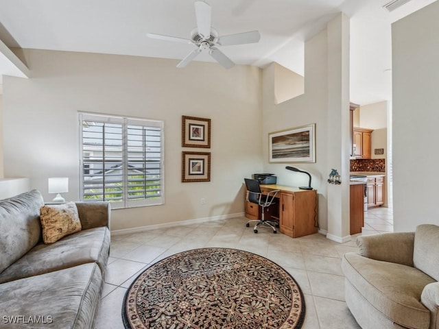 home office featuring a towering ceiling, baseboards, a ceiling fan, and light tile patterned flooring