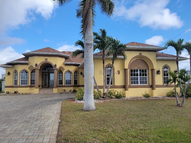 mediterranean / spanish house featuring a front lawn