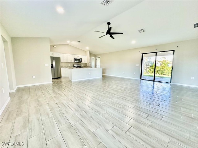 unfurnished living room featuring ceiling fan, lofted ceiling, sink, and light hardwood / wood-style floors