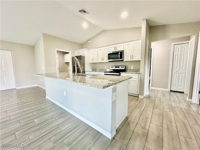 kitchen featuring white cabinetry, stainless steel appliances, sink, and a kitchen island with sink