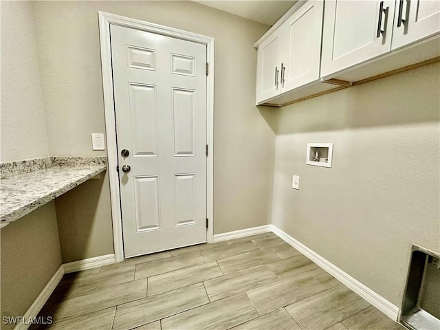 clothes washing area featuring hookup for a washing machine and cabinets