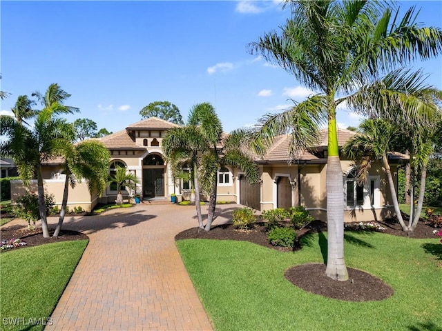 mediterranean / spanish-style home with a front lawn